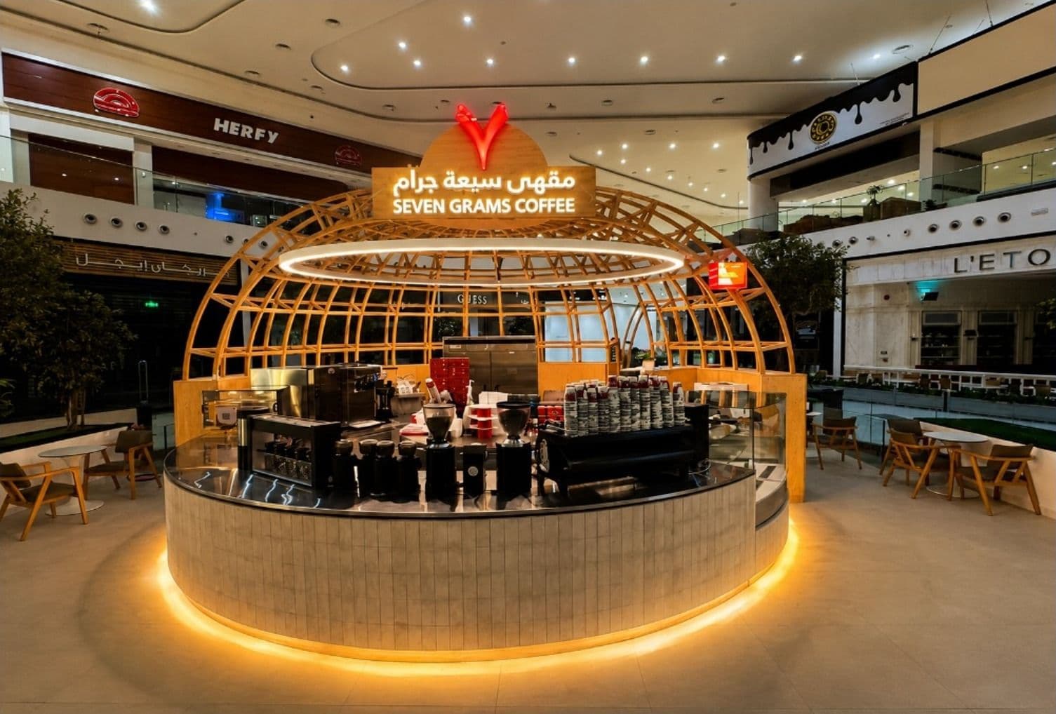 Circular Seven Grams Coffee kiosk under a curved timber dome frame in a mall atrium